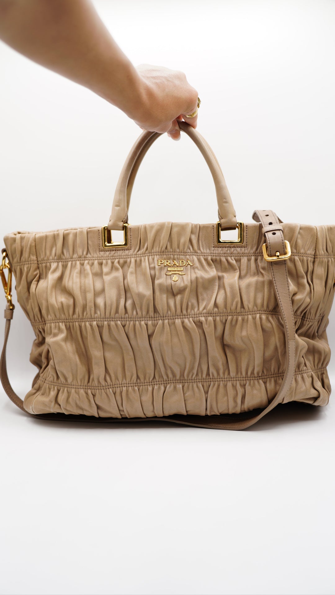 Beige handbag with gold accents on a white background